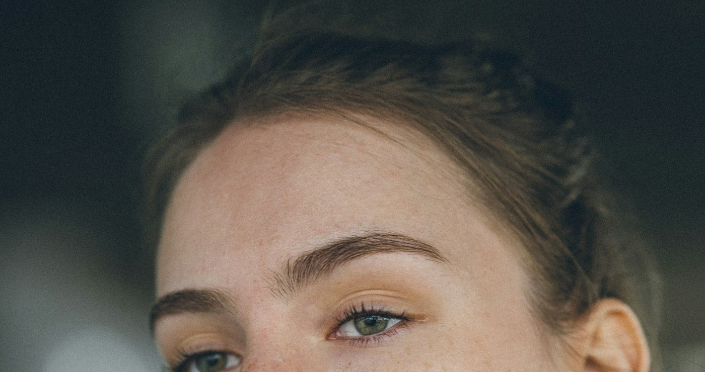 A close portrait of a young woman looking straight ahead.